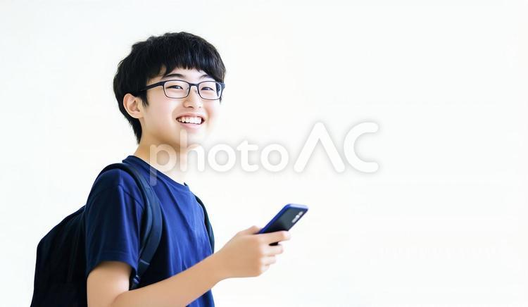 スマホを持ってほほえむアジア人の男子学生 男子学生,学生,メガネの写真素材