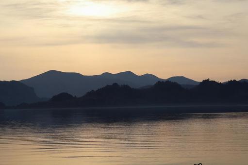 オレンジ色の朝焼けの空と山並みと湖の風景 オレンジ色,朝焼け,空の写真素材