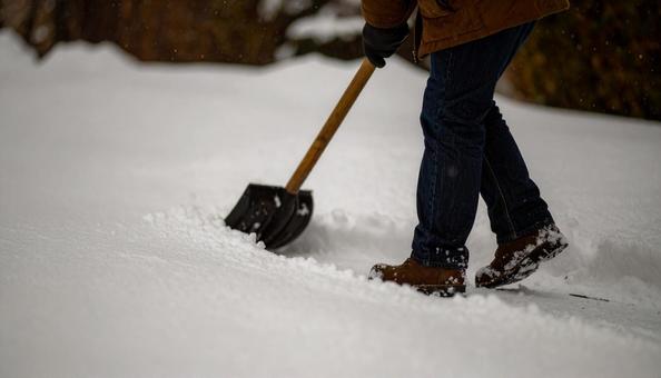 大雪が降った日の翌日の朝に雪かきする男性 大雪が降った日の翌日の朝に雪かきする男性 の写真