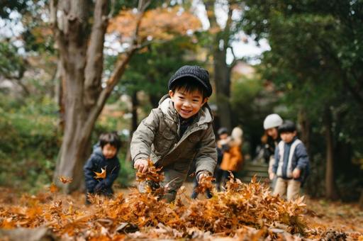 落ち葉で遊ぶ子ども-3 落ち葉で遊ぶ子ども-3の写真