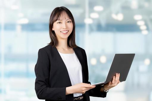 パソコンを持つ女性・ビジネスウーマン パソコンを持つ女性・ビジネスウーマン 女性,パソコン,笑顔の写真素材