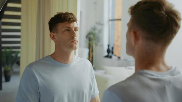 洗面所の鏡で自分の顔を見ている男性 男性,外国人,欧米人の写真素材