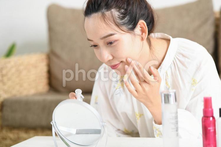 鏡を見ながらスキンケアをする女性 スキンケア,女性,ビューティーの写真素材