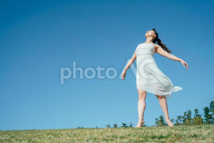 空と白いワンピースの踊る女性（深呼吸） 深呼吸,リフレッシュ,デトックスの写真素材