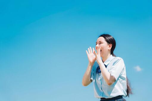 応援をする女子高校生 高校生,応援,青空の写真素材
