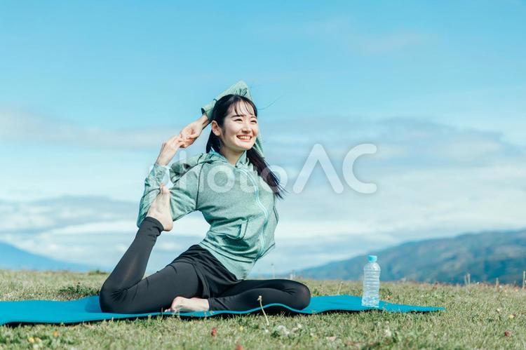 屋外でヨガをする女性（鳩のポーズ） ヨガ,運動,外ヨガの写真素材
