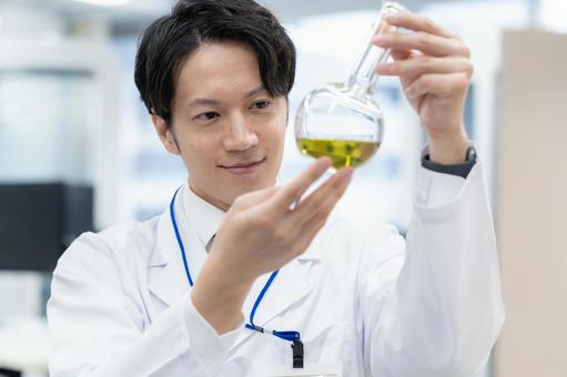 実験をする白衣の若い男性研究者 実験をする白衣の若い男性研究者 研究,実験,サイエンスの写真素材