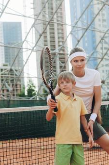 優しくサポートする女性テニスプレーヤー 男の子,女性,外国人の写真素材