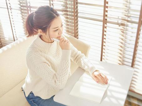 Image of a woman taking notes in a notebook, household account book, to worry, study, JPG