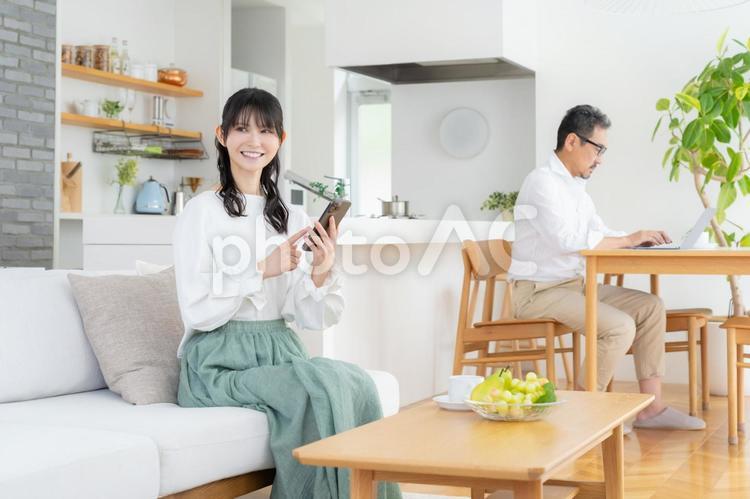 リビングでスマホを見るミドルの夫婦 夫婦,家族,ミドルの写真素材
