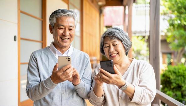スマホを楽しむシニア夫婦 スマホを楽しむシニア夫婦の写真