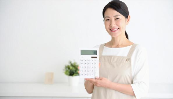 電卓を持つミドル日本人女性の主婦 電卓を持つミドル日本人女性の主婦の写真