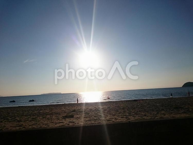 夕焼け前の太陽の輝き 散歩する人の小さなシルエット たそがれ,ひかり,光の写真素材
