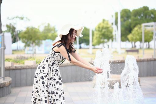 公園の噴水で遊ぶ女性 公園の噴水で遊ぶ女性の写真