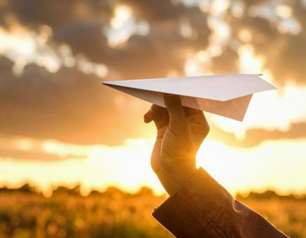 紙飛行機を持った手 紙飛行機を持った手の写真