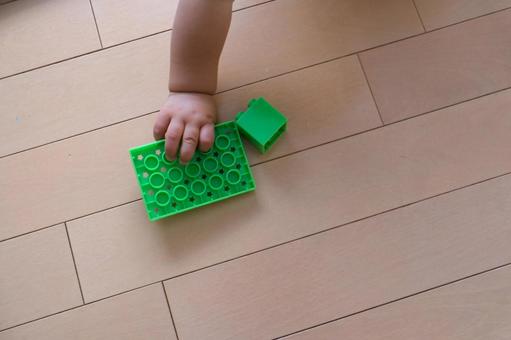 フローリングでブロックを持つ赤ちゃんの手 フローリングでブロックを持つ赤ちゃんの手 ブロック,レゴ,赤ちゃんの写真素材