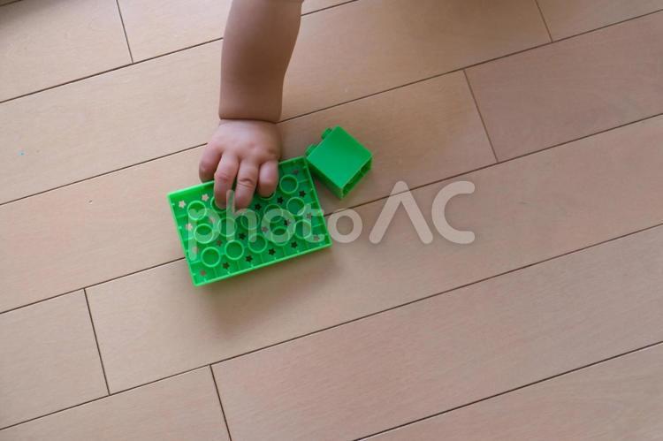フローリングでブロックを持つ赤ちゃんの手 ブロック,レゴ,赤ちゃんの写真素材