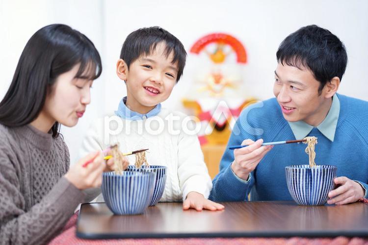 カメラ目線の男の子と年越しそばをふーふーする女性と家族 家族,男性,人物の写真素材