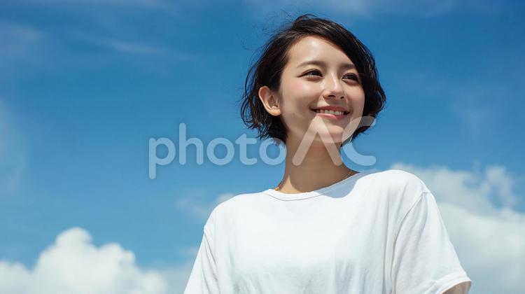 青空の下で微笑む、爽やかな日本人女性 女性,日本人,アジア人の写真素材