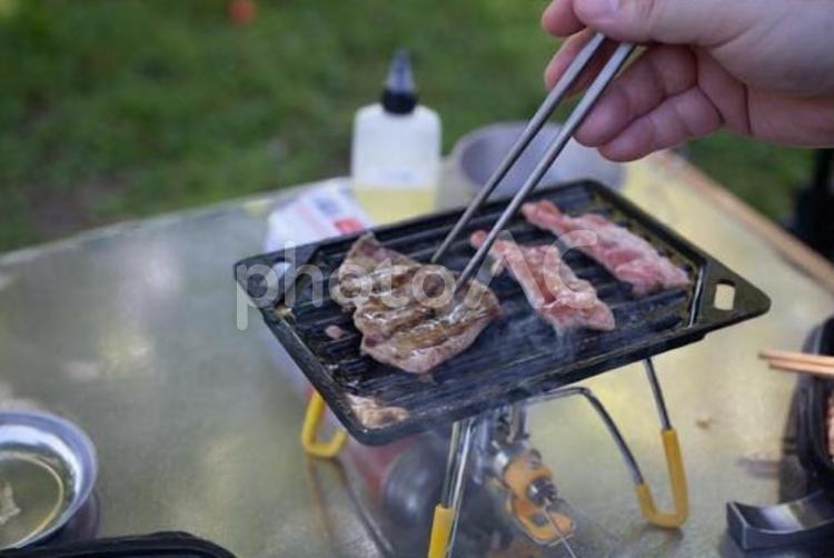 ソロキャンプで焼肉を楽しむ男性 ソロキャンプ,キャンプ,シングルバーナーの写真素材