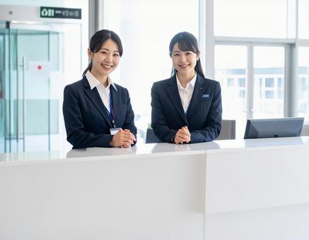 受付コーナー内に座る笑顔の受付嬢 受付コーナー内に座る笑顔の受付嬢の写真
