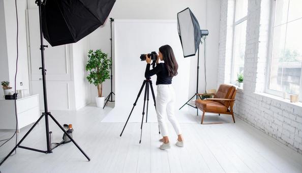 部屋で撮影する日本人女性フォトグラファー 部屋で撮影する日本人女性フォトグラファーの写真