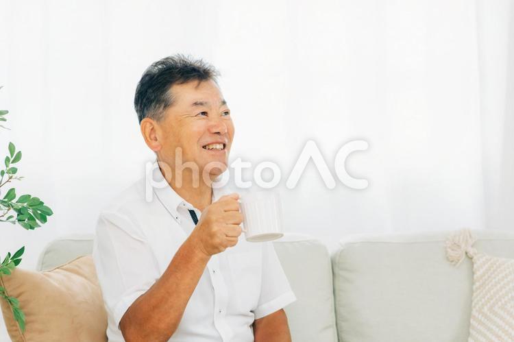 ソファでコーヒーを飲む高齢者男性 コーヒー,お茶,高齢者の写真素材