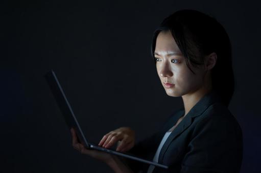 女性が画面を見ながら微笑む 女性,ノートパソコン,持つの写真素材