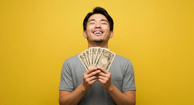 大金を手にして喜ぶ男性 大金を手にして喜ぶ男性の写真