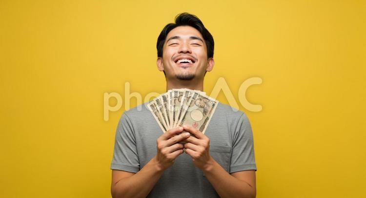 大金を手にして喜ぶ男性 お金,大金,お札の写真素材