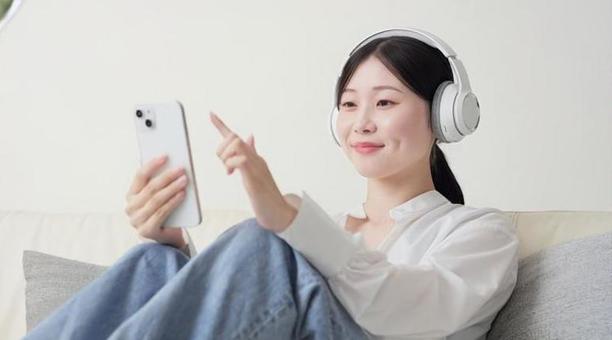 ワイヤレスヘッドフォンで音楽を聞く女性 ワイヤレスヘッドフォンで音楽を聞く女性 女性,ワイヤレス,聴くの写真素材