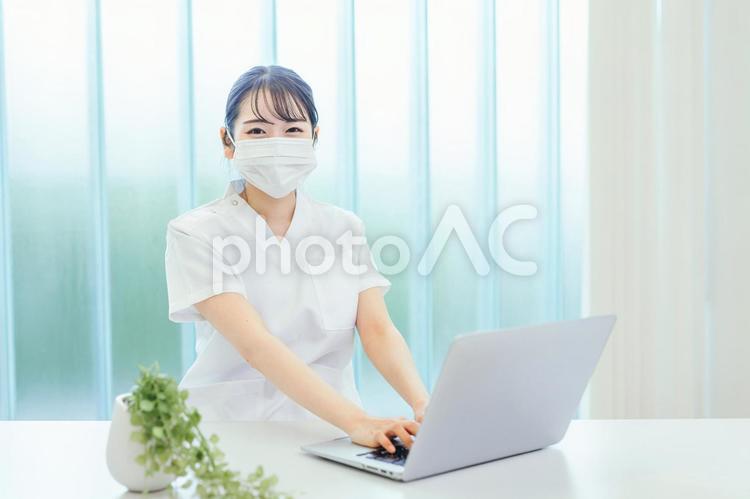 マスクをしてパソコンを使う白衣姿の女性 看護師,医療事務,ナースの写真素材
