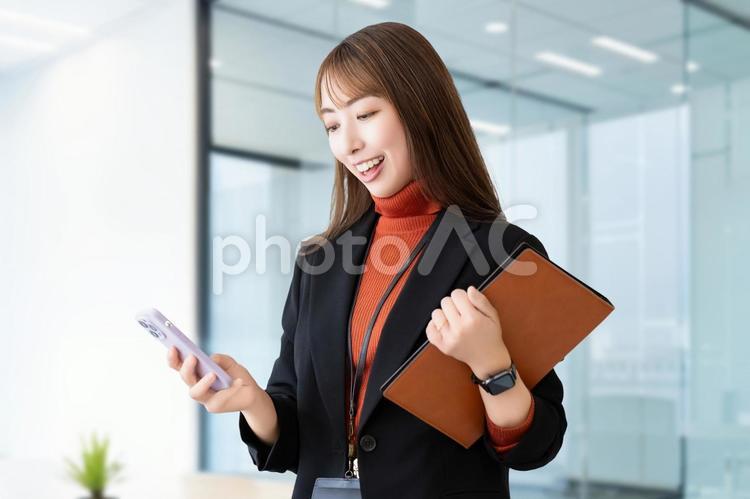 スマホとバインダーを持つ笑顔の女性 女性,ビジネス,笑顔の写真素材