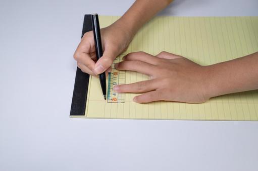 黄色いレポート用紙にペンと定規で線を引く メモ,書く,手の写真素材