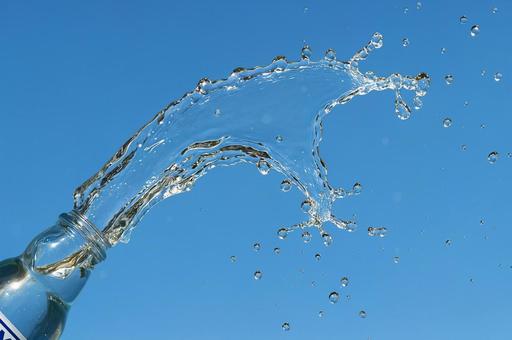 空に弧を描くラムネの水しぶき 空に弧を描くラムネの水しぶきの写真