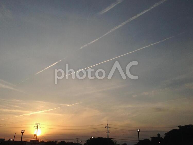 夕日の光を浴びて輝く飛行機雲 飛行機雲,輝く,太陽の写真素材