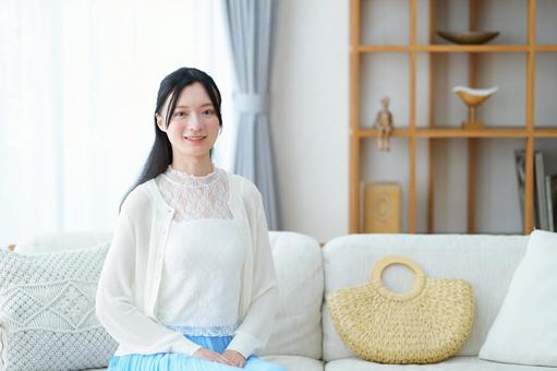 ソファに座りカメラ目線の女性 女性,ソファ,座るの写真素材