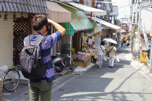 石切参道商店街を撮影する観光客の後ろ姿 石切参道商店街,男性,観光客の写真素材