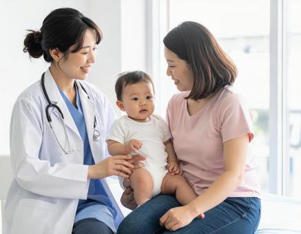 赤ちゃん定期健診をする女性医師と母親の写真