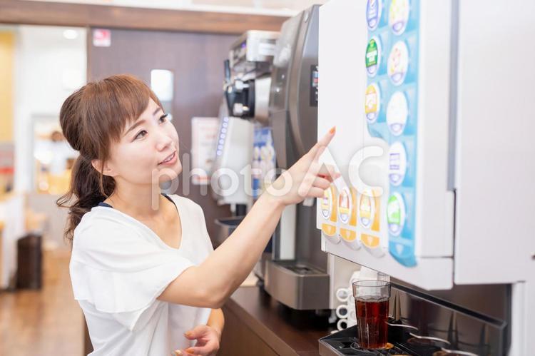 ドリンクバーで飲み物を選ぶ女性 ドリンクバー,フリードリンク,ドリンクの写真素材