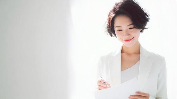 書類を確認する女性 書類を確認する女性の写真