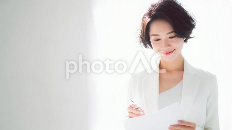 書類を確認する女性 女性,白背景,ビジネスの写真素材
