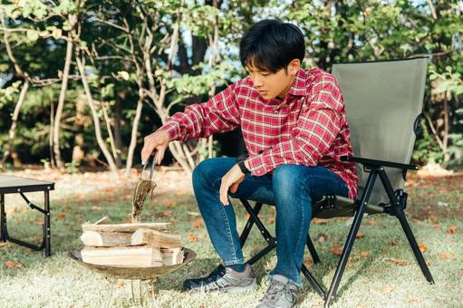 休日に一人キャンプする男性 アウトドア 休日に一人キャンプする男性 アウトドア キャンプ,一人キャンプ,火おこしの写真素材