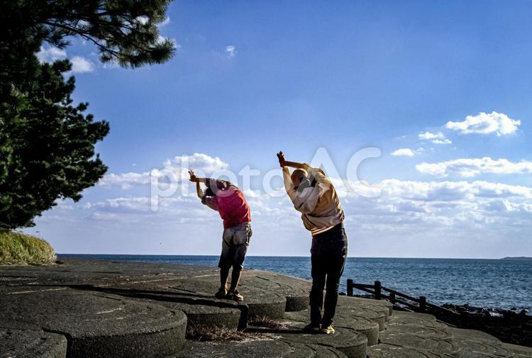 ＜素材＞朝の海でストレッチをする親子 家族,海,空の写真素材