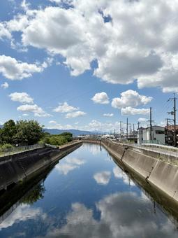 川に映った美しい空 縦 川に映った美しい空 縦の写真
