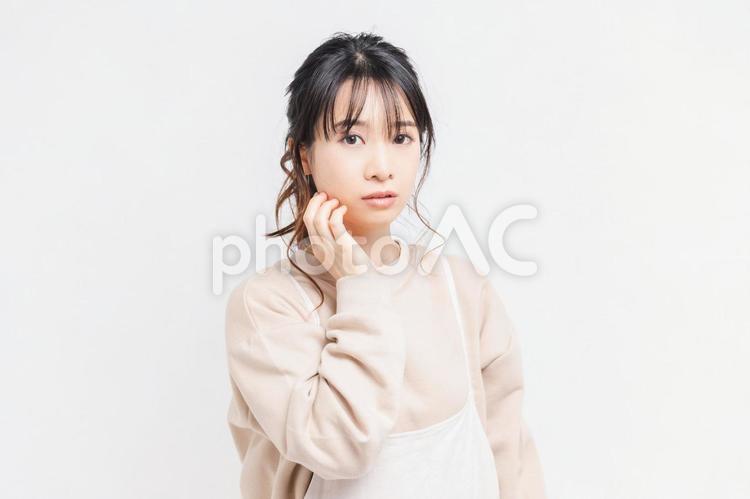 白い背景の前に立ってポーズをとる若い女性 女性,白背景,立つの写真素材