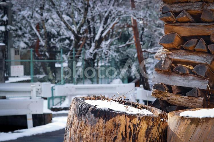 雪の降る街角に積まれた薪と切り株 薪,切り株,雪の写真素材
