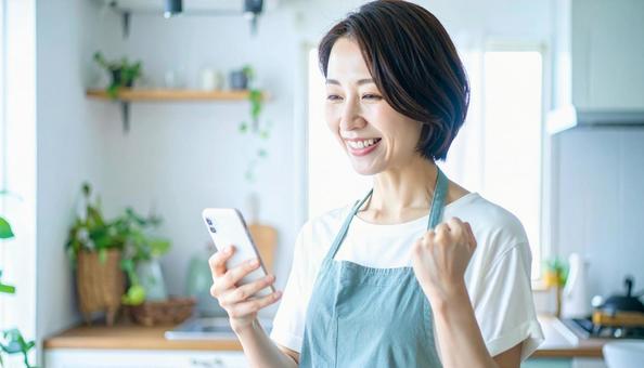 スマホでポイ活する笑顔の女性 スマホでポイ活する笑顔の女性の写真