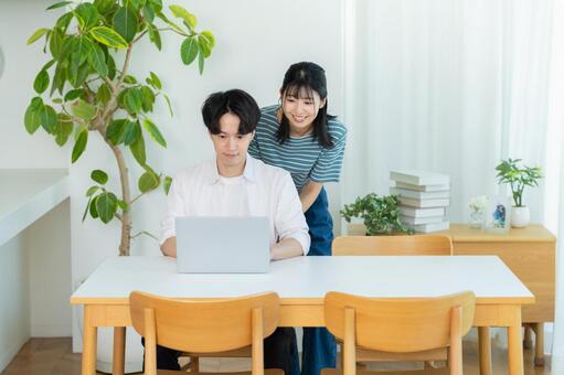 パソコンを見るカップル ノートパソコン,笑顔,カップルの写真素材