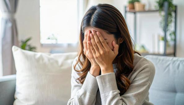顔を両手で覆って泣く日本人女性 顔を両手で覆って泣く日本人女性の写真